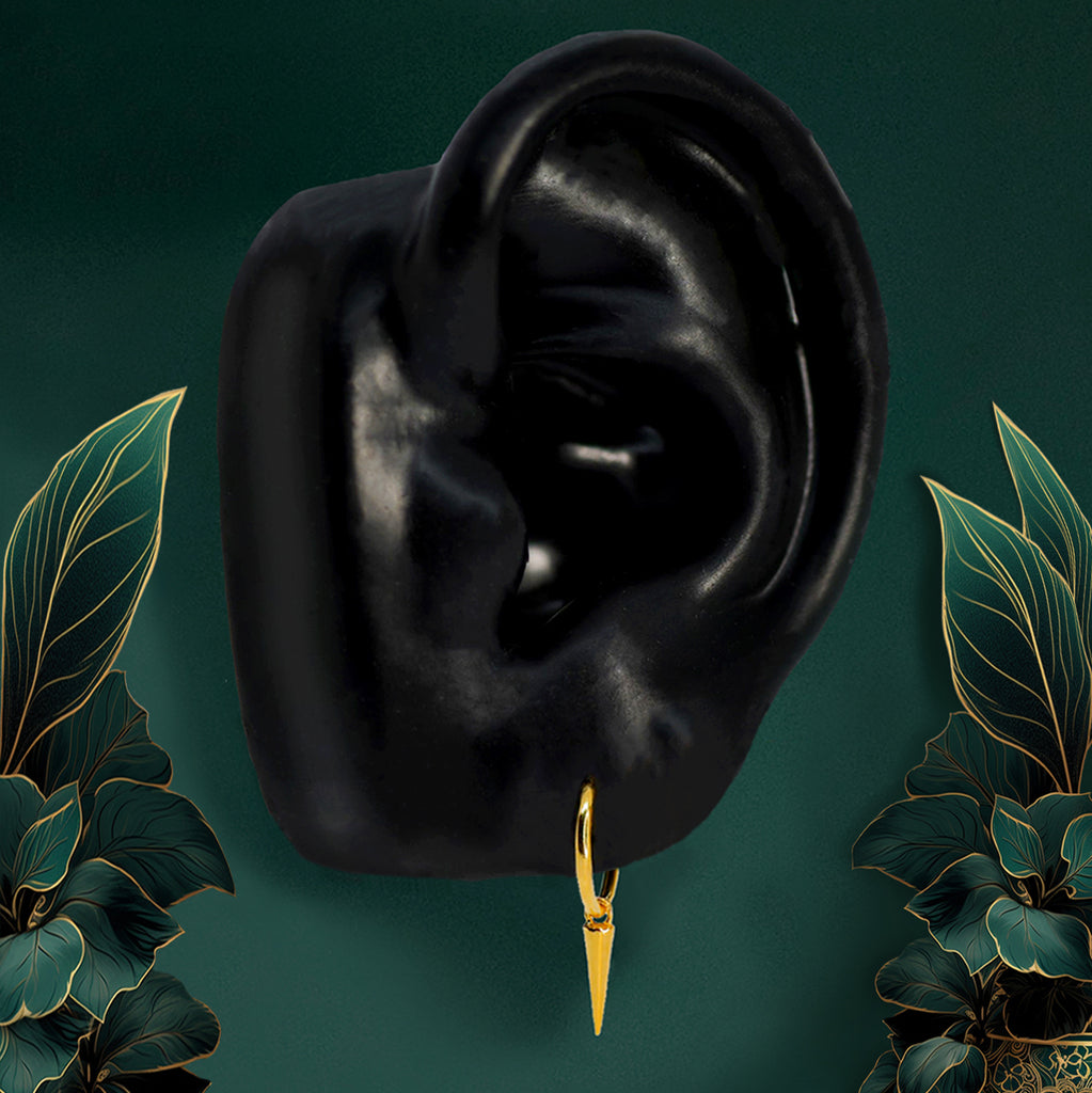 Gold spike dangle earrings shown from the front, combining huggie hoops with an edgy spike design