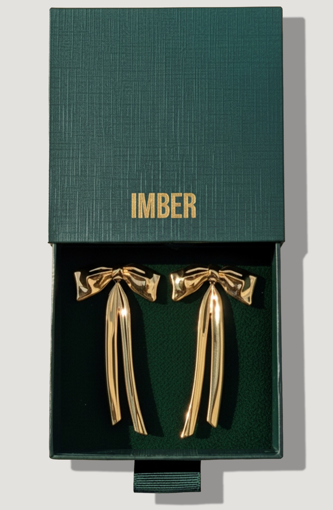 IMBER Bow gold bow drop earrings in open green gift box, top view