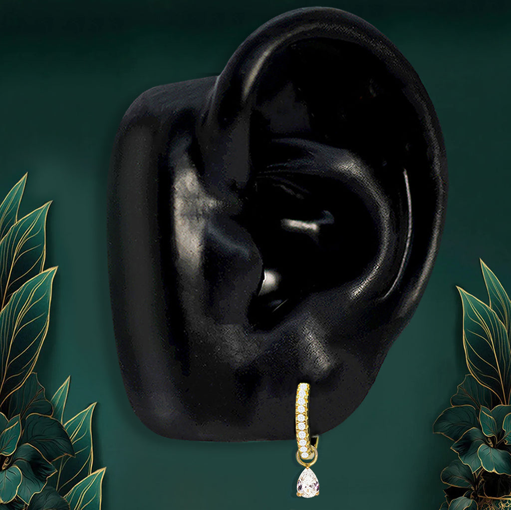 IMBER Classic Teardrop Hoops in gold with a clear teardrop stone, on ear display