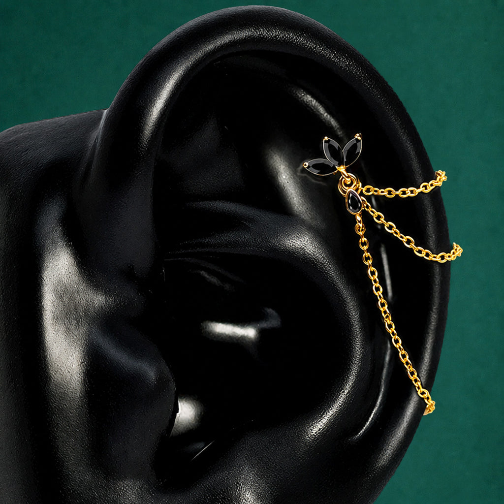 IMBER Eternal Helix Black floral stud in gold with black stones and chains, on display