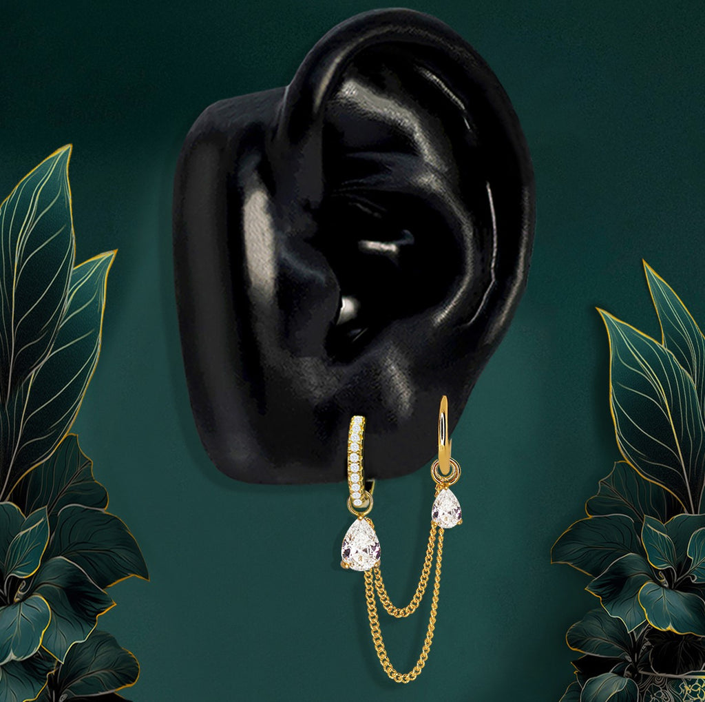 Gold double lobe piercing earrings with teardrop pendants and chain