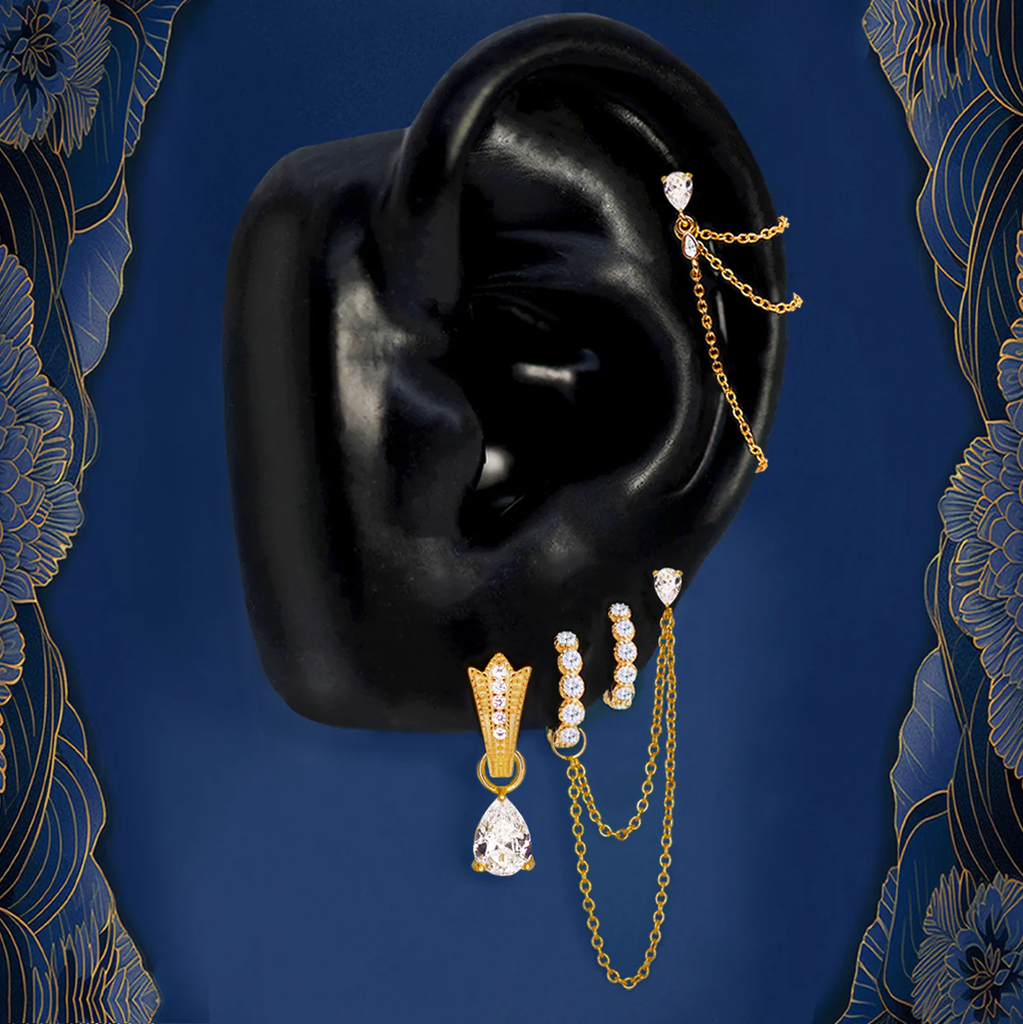 Gold ear stack with hoops, studs, chains, and teardrop pendant