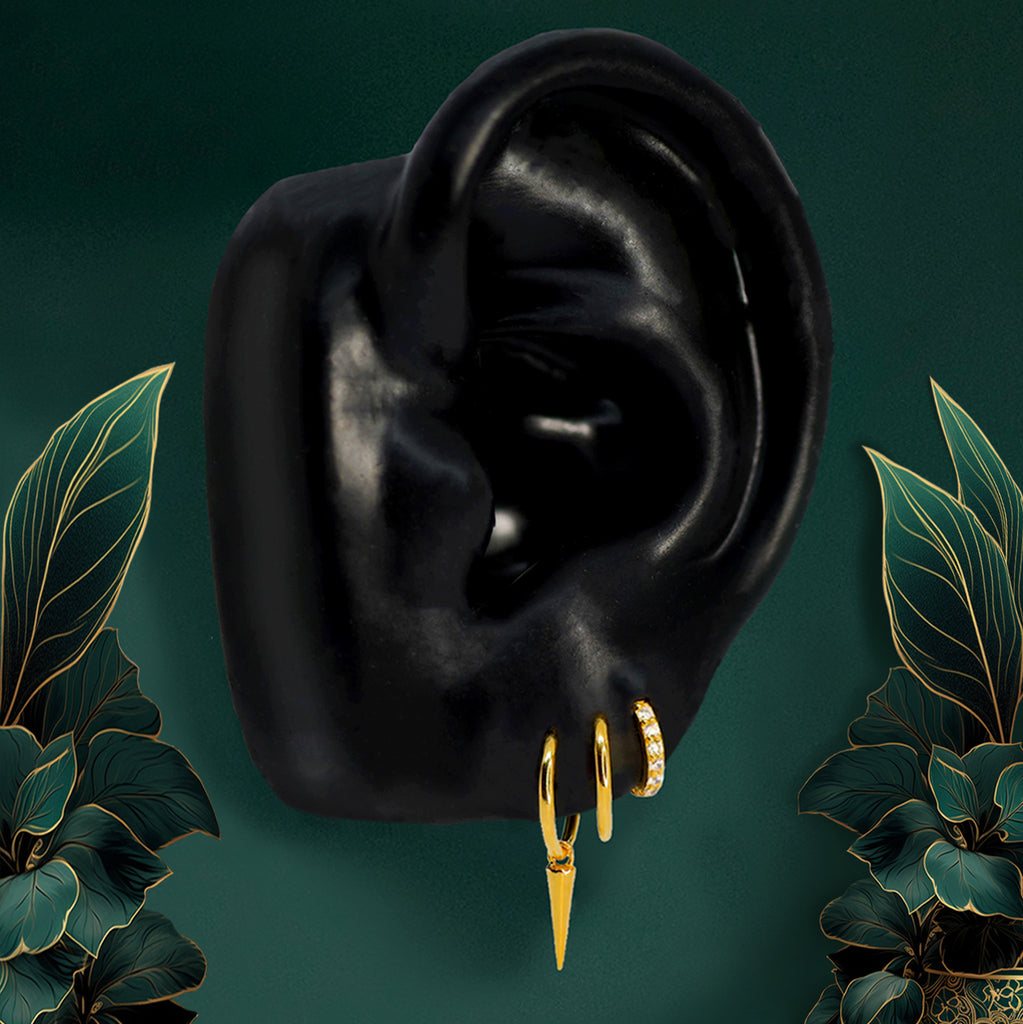 Gold hoop earrings styled in a triple lobe piercing for an edgy everyday look
