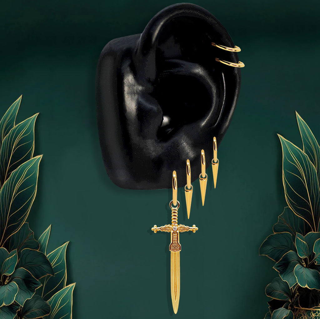 Bold gold statement earrings featuring spike drops and a sword charm on gold hoops