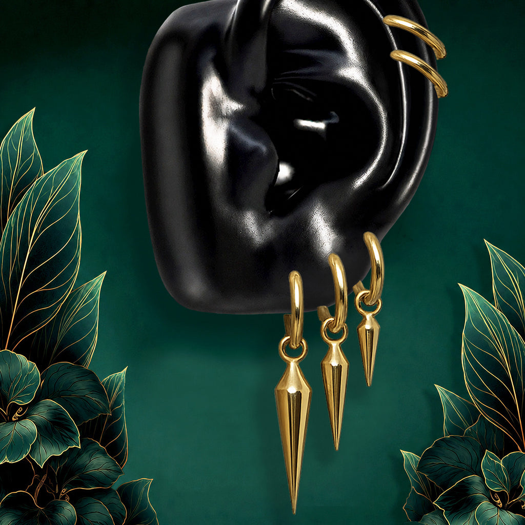 IMBER Zenith earring stack in gold titanium with spike huggies and spike charms, on display
